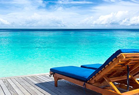 two sunbeds on decking overlooking the ocean