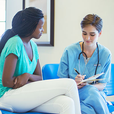 A nurse and patient talking in hospital